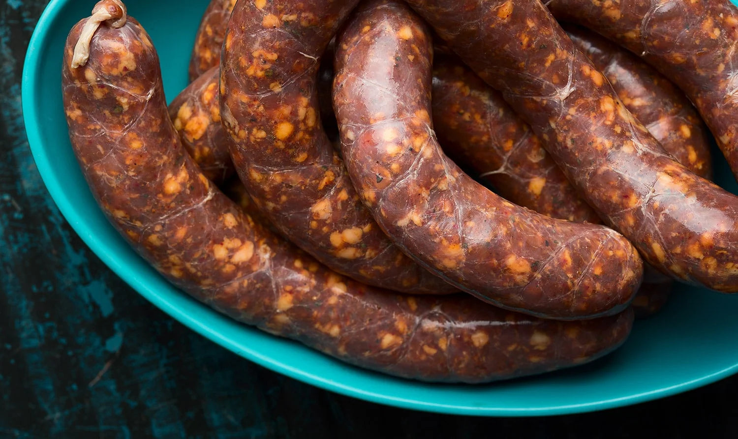 Closeup of sausages grilling over a gas grill